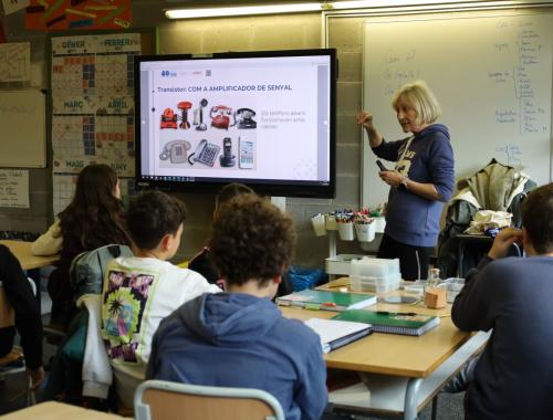 Mercedes Saludes explicando al alumnado de primaria cómo funcionaban los teléfonos antiguos y qué función tenía en la comunicación el transistor.