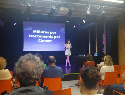 Xerrada de Carla Riera Llobet a Vil·la Urània per la Nit de la Recerca, sobre l'escenari amb la presentació al fons