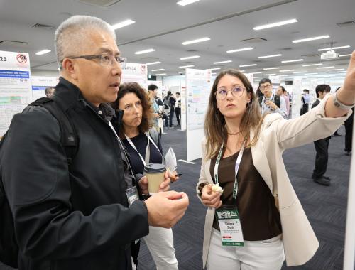 Emma Solà showing her poster to two people at the ISPSD in Japan 2025