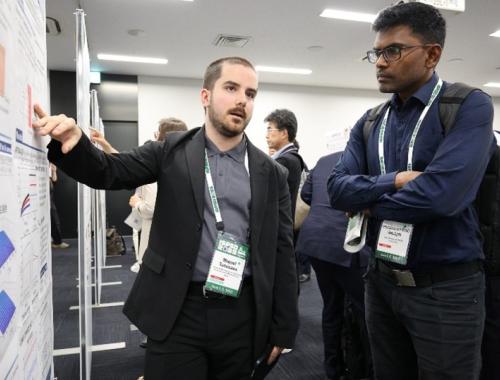 Miquel Tutusaus showing his poster to a person at the ISPSD in Japan 2025