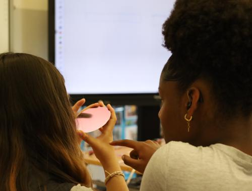 dos alumnas de un centro de discapacidad auditiva mirando una oblea