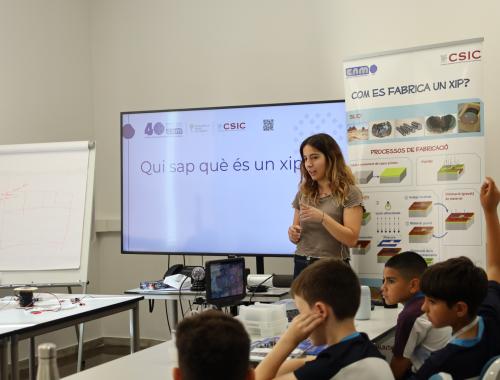Persona de comunicación hablando con los alumnos de primaria sobre chips. 