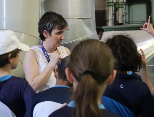 Científica haciendo un tour por sala blanca a alumnado de primaria