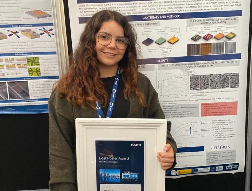 Teresa Elenes Cervantes in front of her poster with the prize for Best Poster Award at the MNE 2025