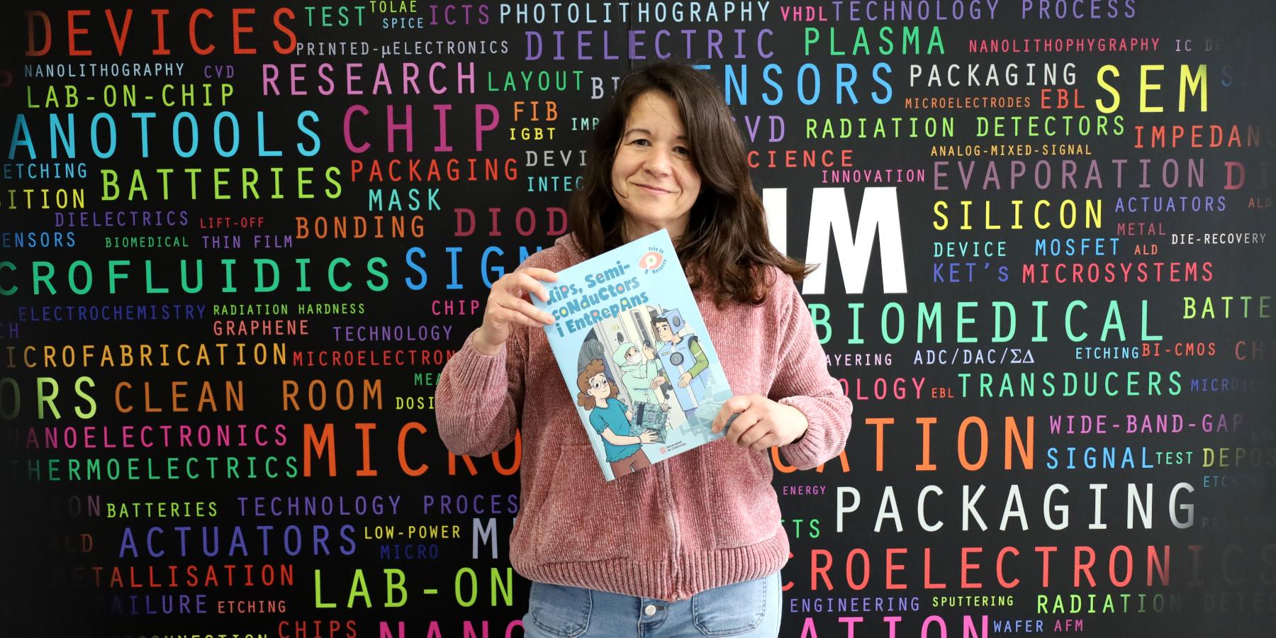 La investigadora Mireia Bargalló amb el conte "Xips, semiconductors i entrepans" a l'entrada de l'IMB-CNM