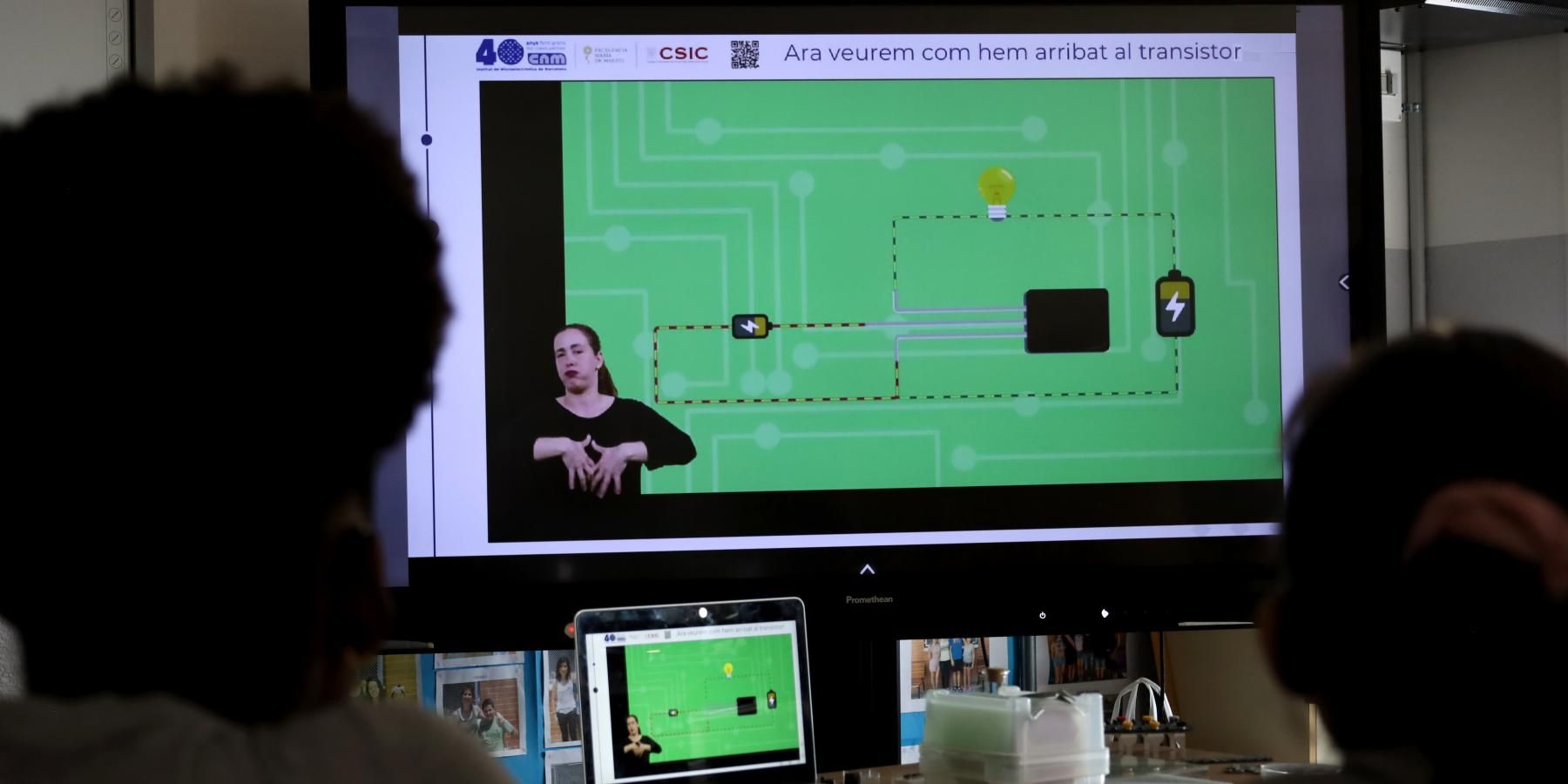 Dues nenes miren el vídeo del transistor amb adaptació a LSC a l'aula de classe
