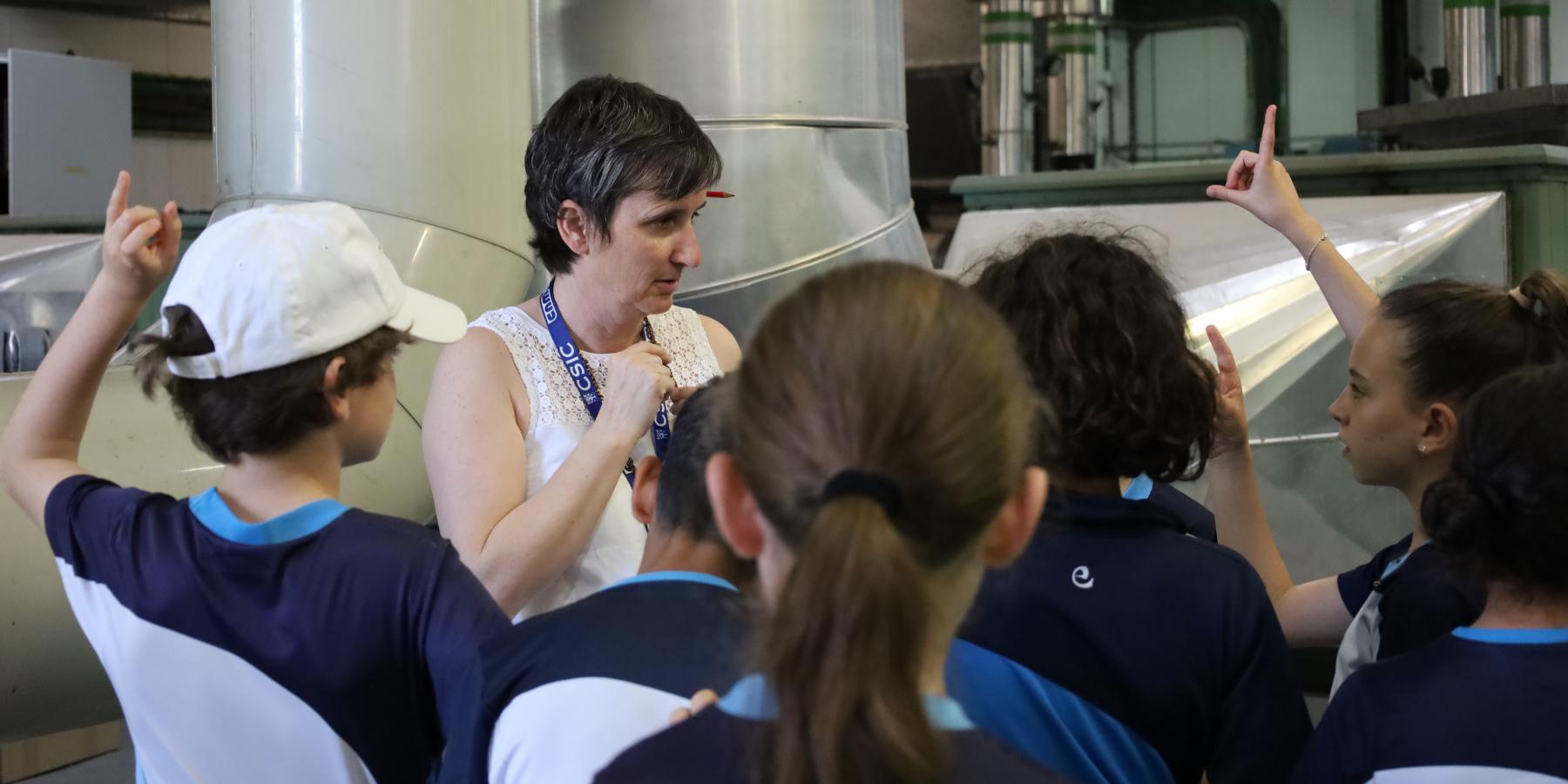 Mujer de mediana edad explicando a niños de primaria 
