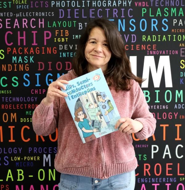 La investigadora Mireia Bargalló amb el conte "Xips, semiconductors i entrepans" a l'entrada de l'IMB-CNM