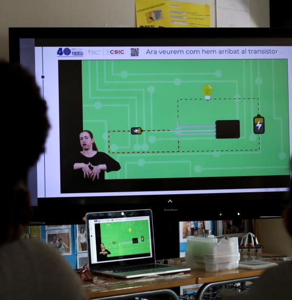 Dues nenes miren el vídeo del transistor amb adaptació a LSC a l'aula de classe